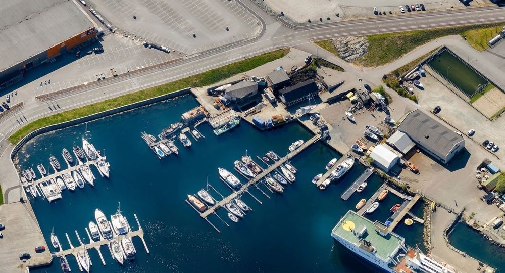Luftfoto av havnen på Tømmerodden med flytebrygger, utriggere, slipp og verkstedbygg.